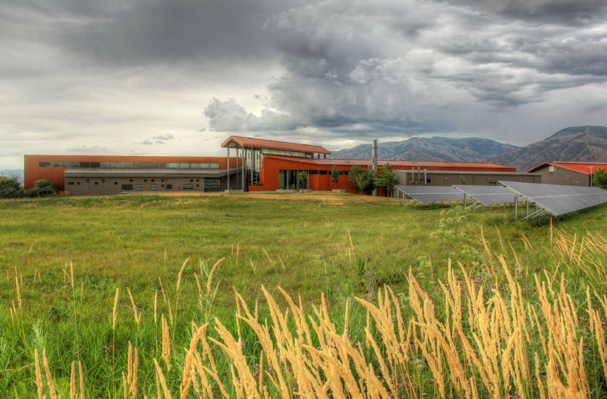 The red and gray Agricultural Teaching and Research Center with a stormy sky in the background.